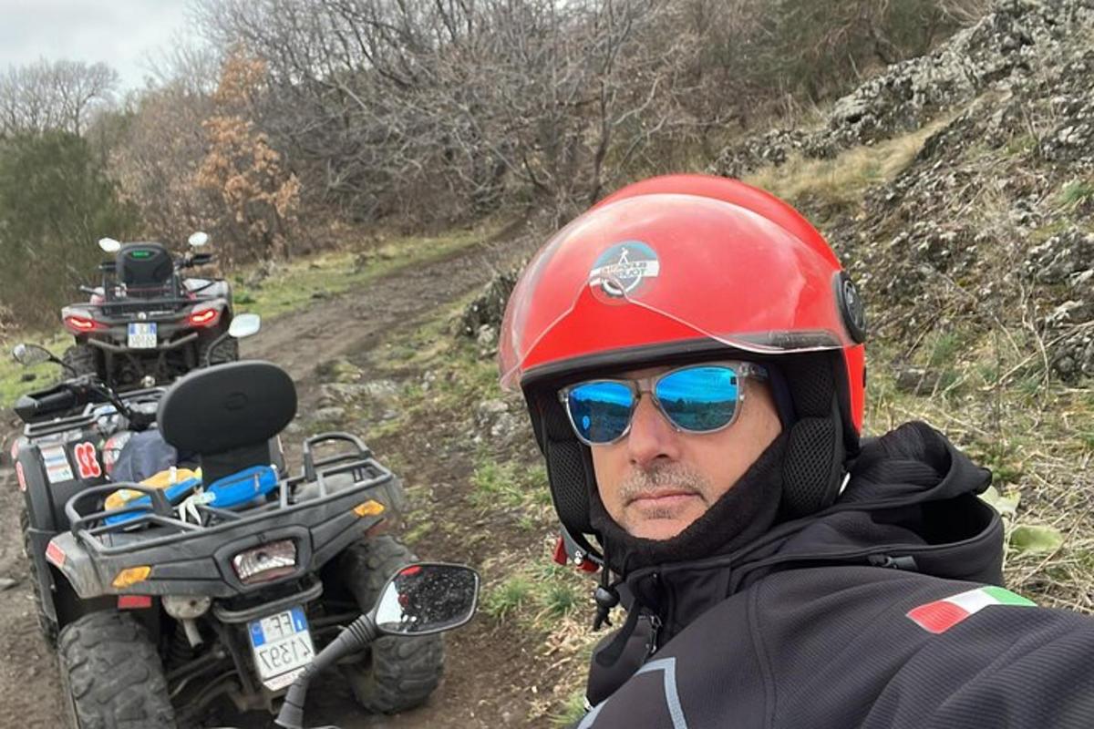 a man wearing a red helmet and sunglasses next to a motorcycle