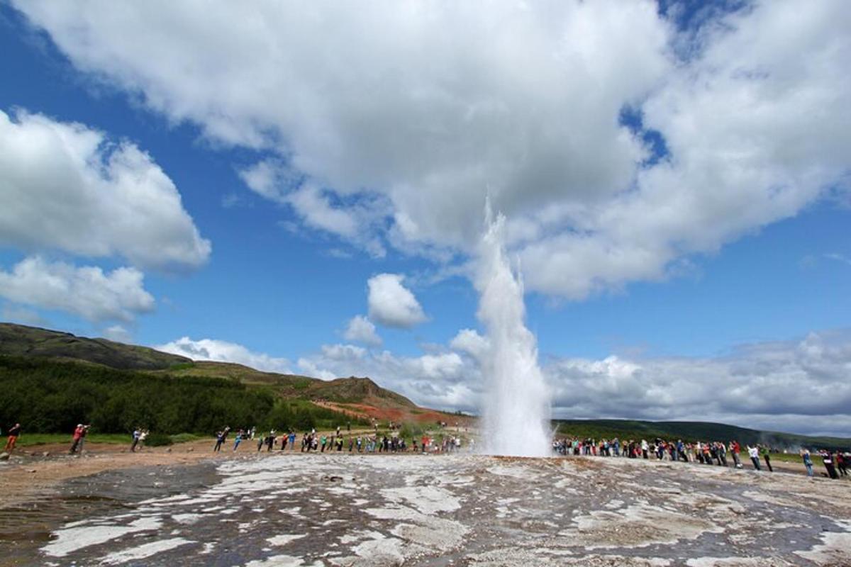 a group of people standing around a geyser