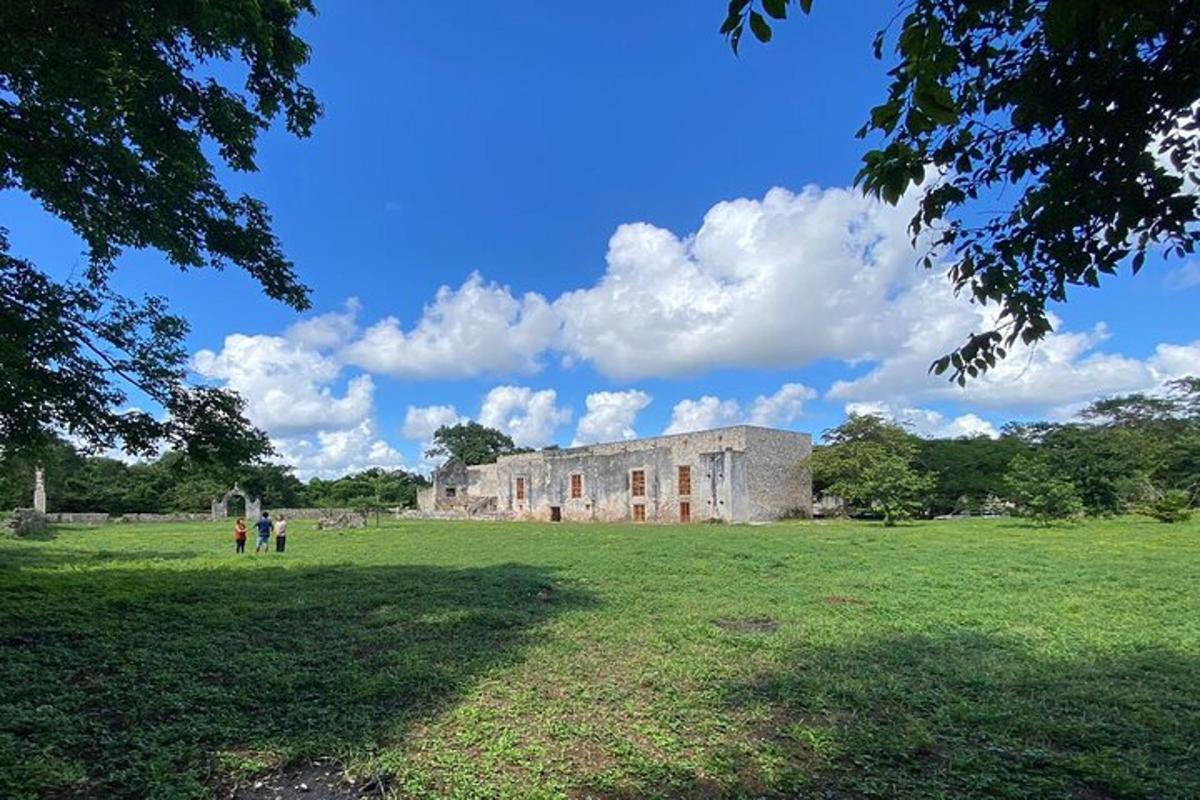 un edifici antic en un camp amb gent passejant