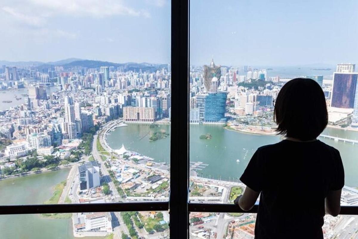 一位女士透过窗户望向城市