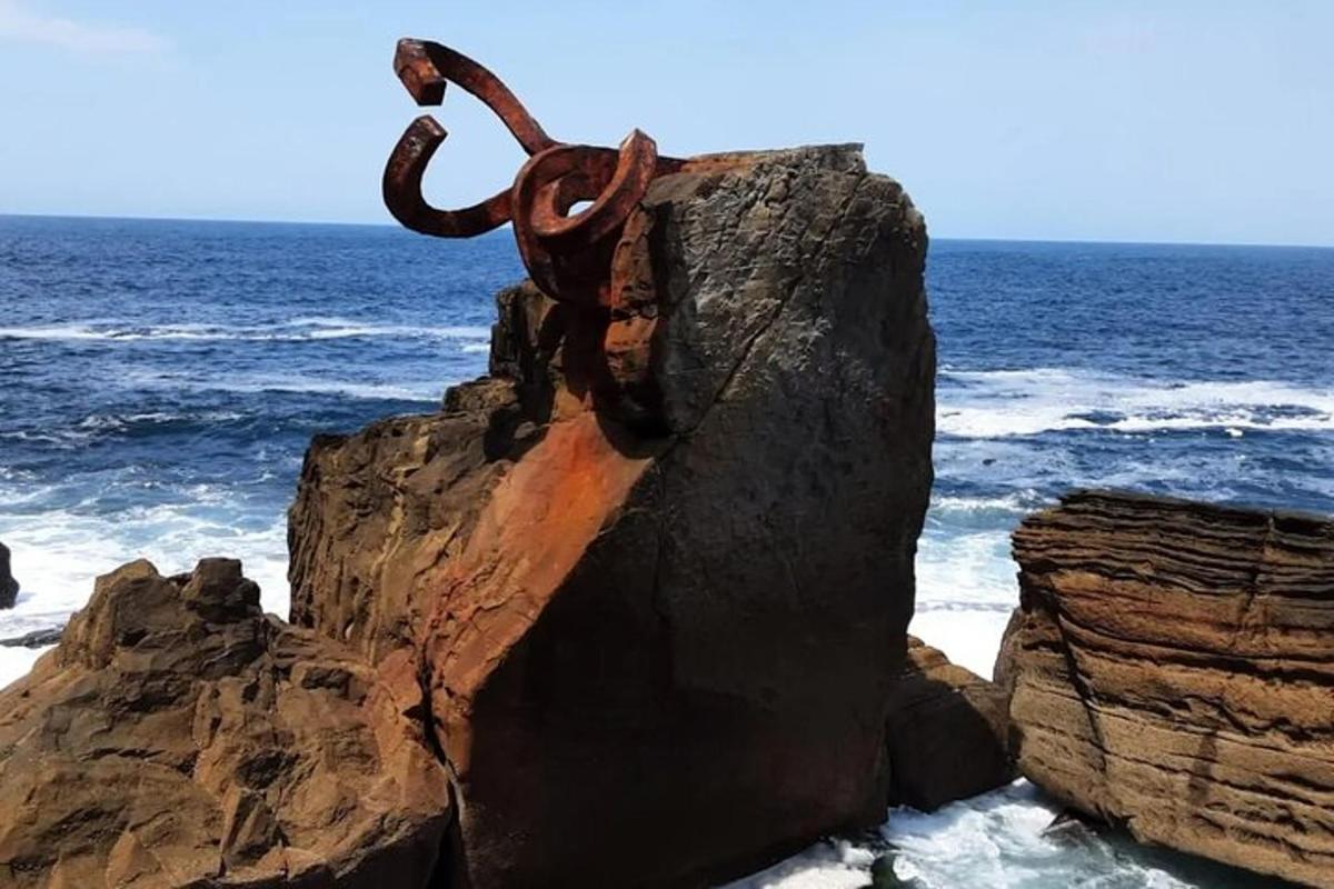 socha na skále u oceánu