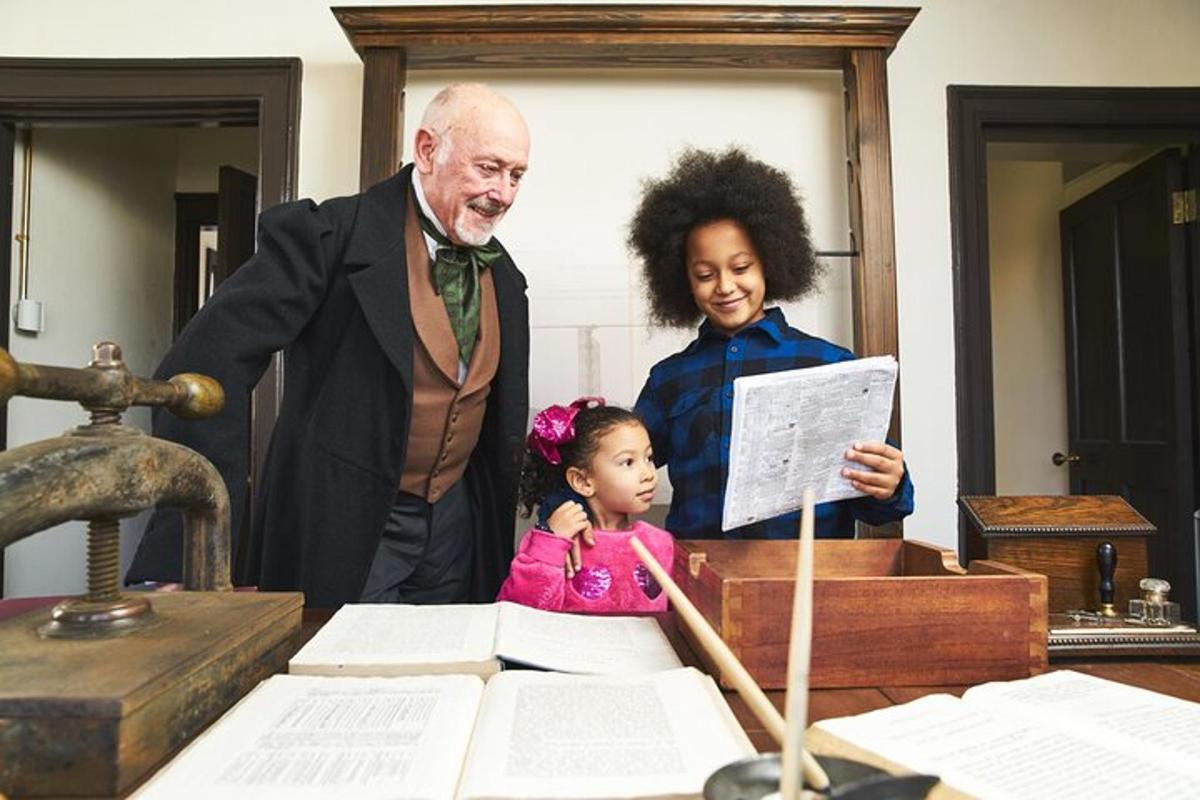 a man and a girl standing next to a table with papers