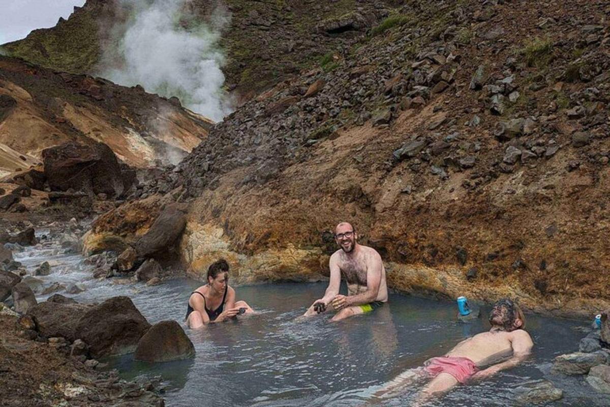 tři lidé sedící ve vodě v řece