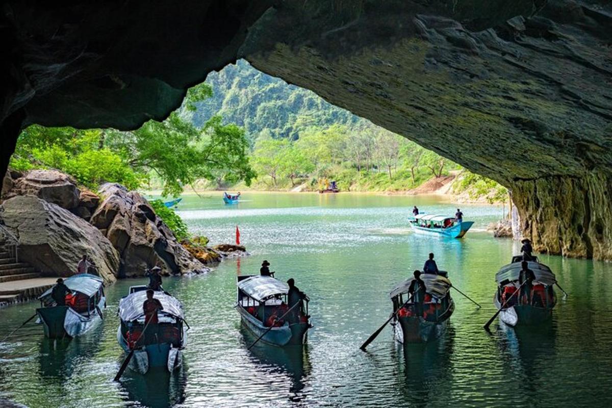 un gruppo di barche nell'acqua sotto una grotta