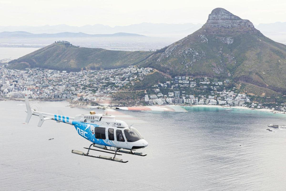 helikopter, ki leti nad vodo z goro
