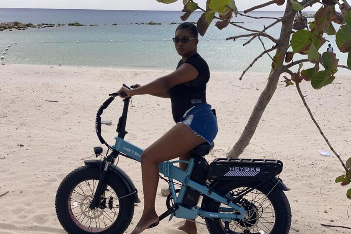 seorang wanita sedang duduk di atas basikal di pantai