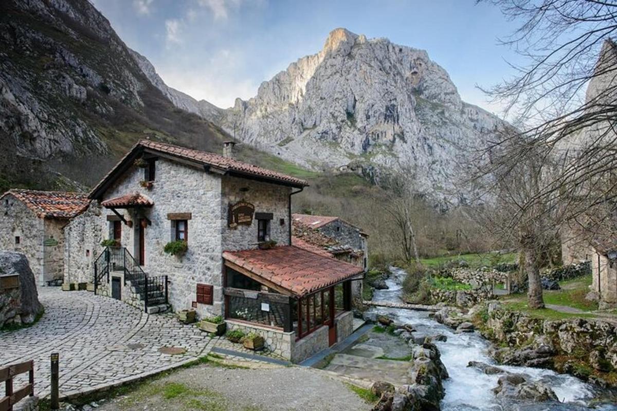a building with a river in front of a mountain