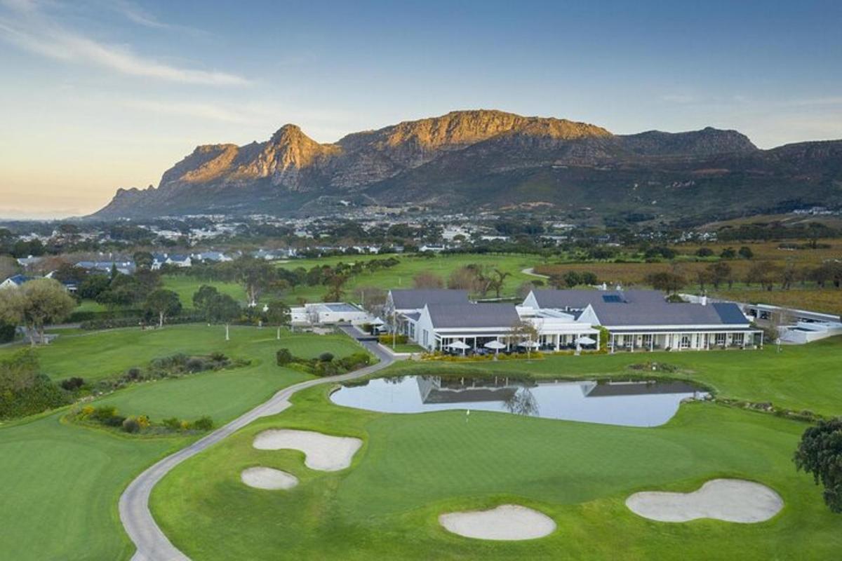 Loftmynd af golfvelli með fjöllum í bakgrunni