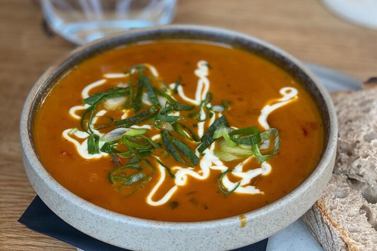 en skål suppe på et bord med en sandwich
