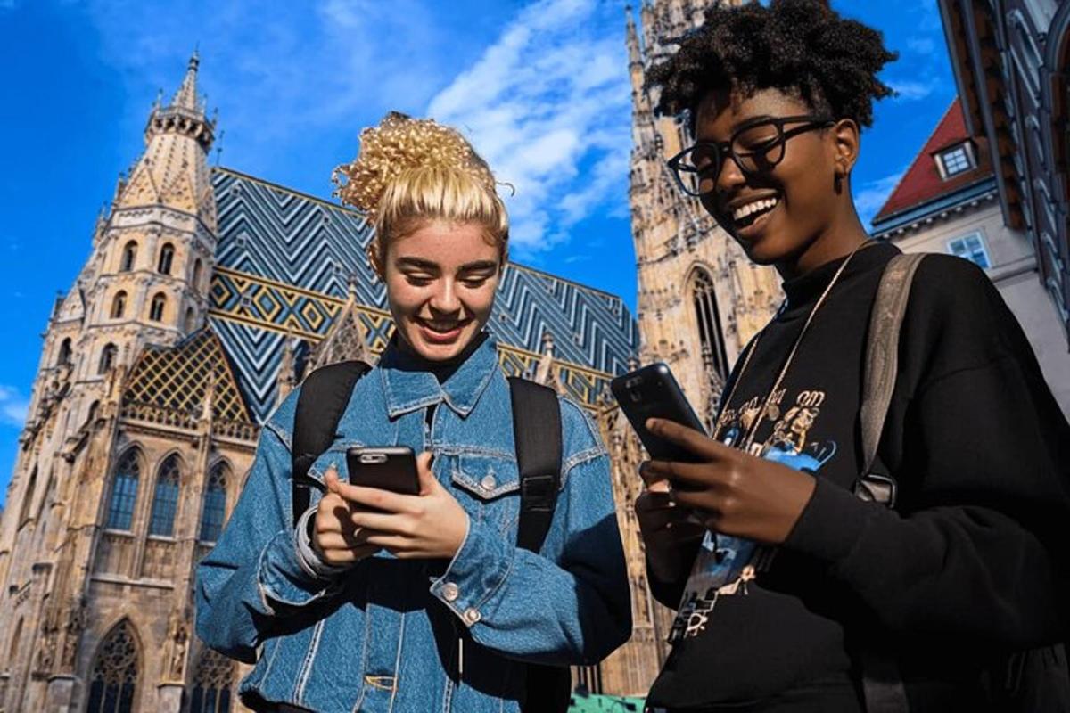 dvě ženy se smějí a dívají se do svých mobilních telefonů