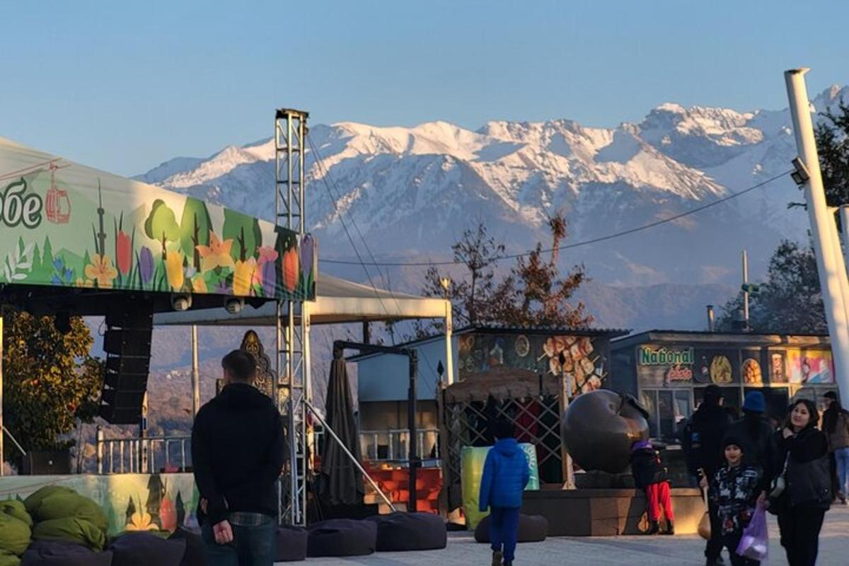 un grup de persones caminant davant d'un edifici amb muntanyes