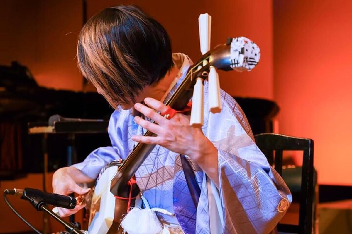 seorang wanita bermain gitar dengan mikrofon