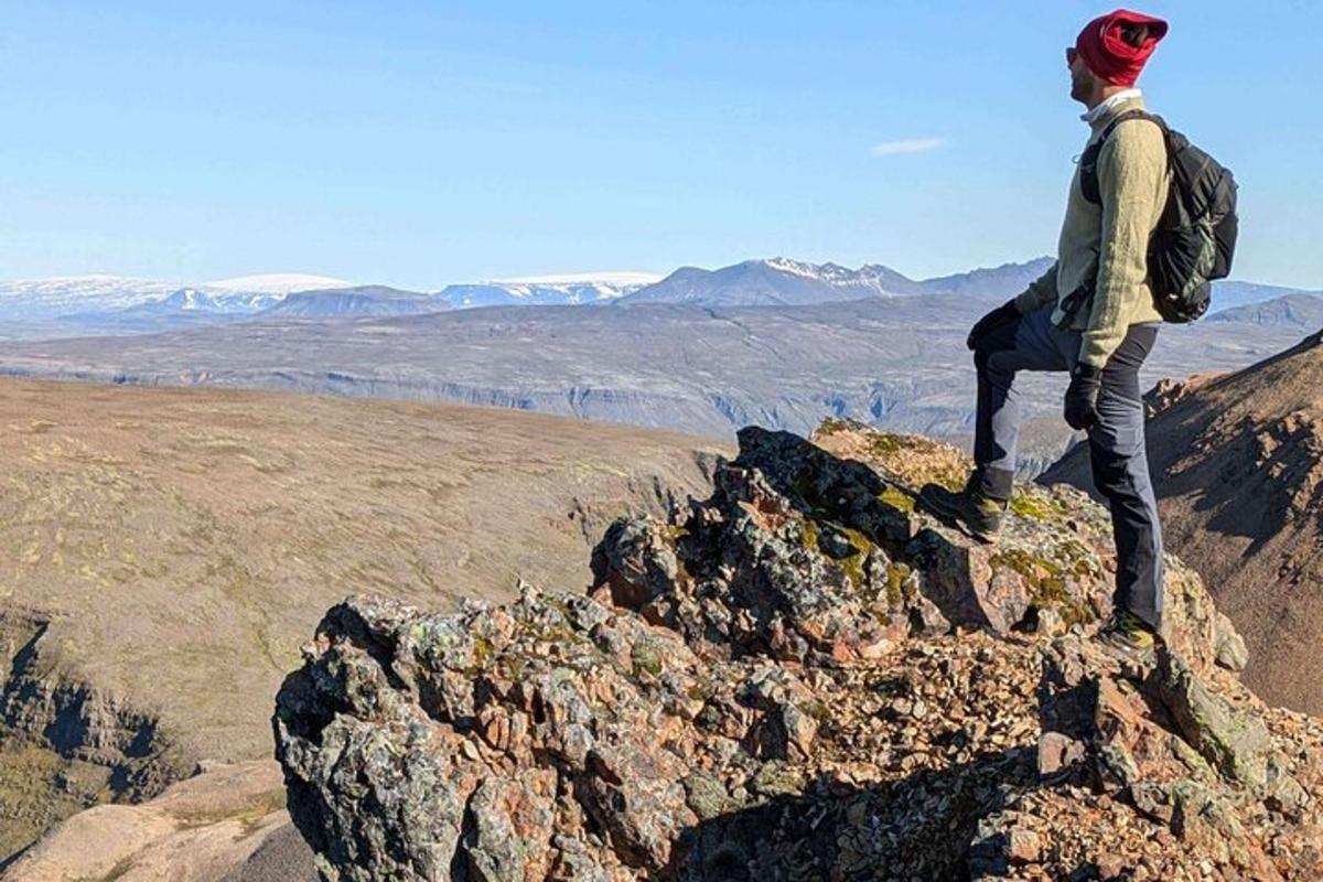 maður sem stendur á fjallstindi