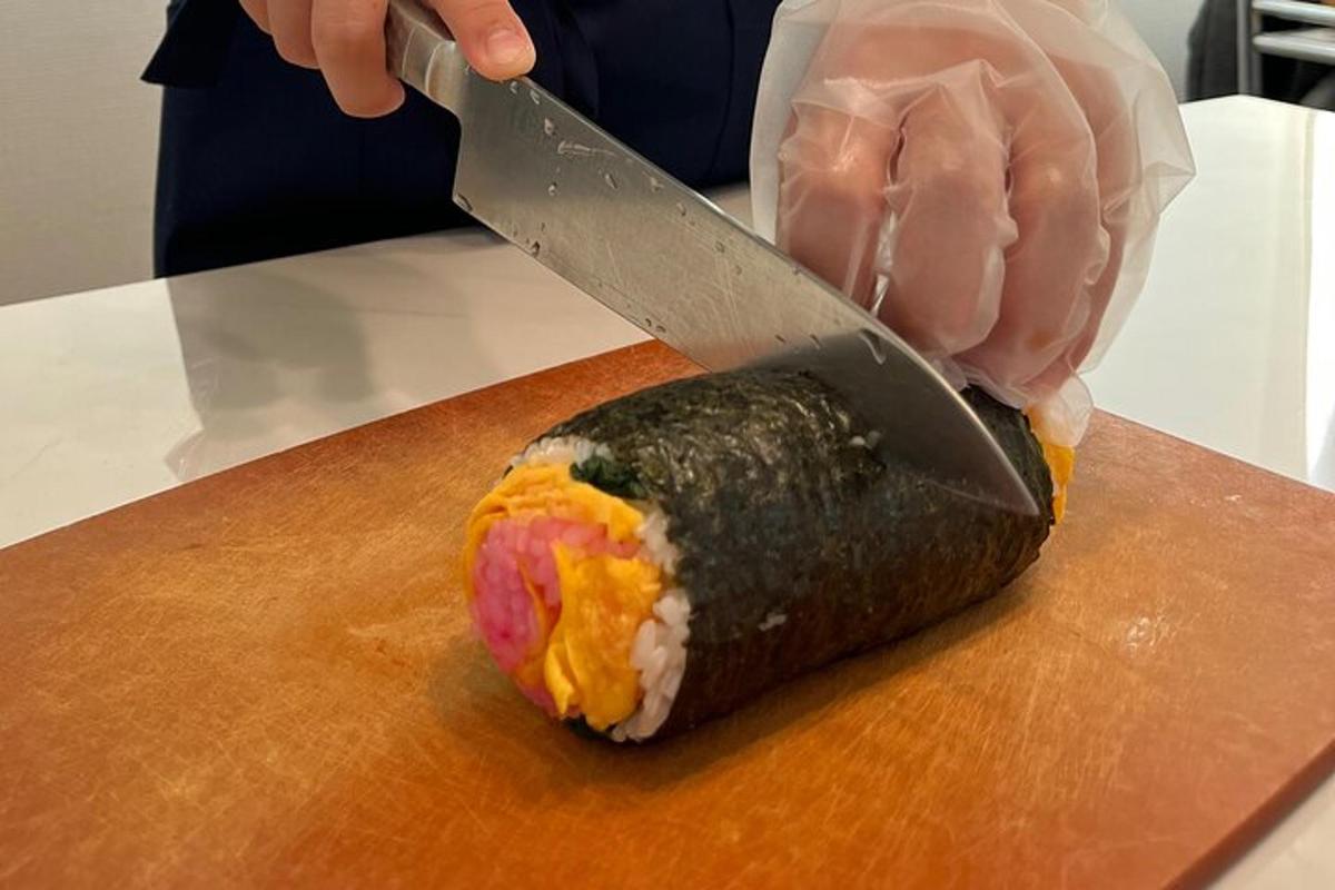 包丁を持って寿司を切っている人