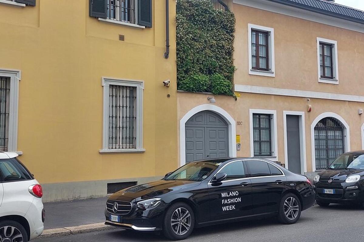 Un coche negro aparcado delante de un edificio amarillo.