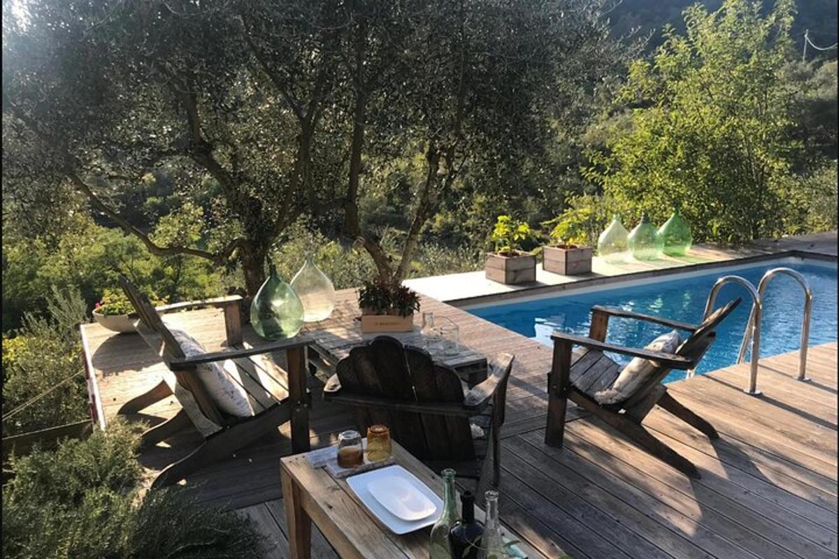 a wooden deck with a table and chairs next to a pool