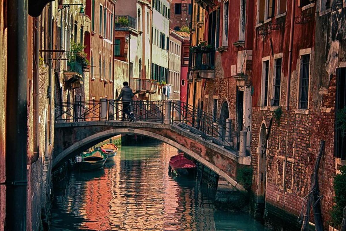 un home caminant per un pont sobre un canal