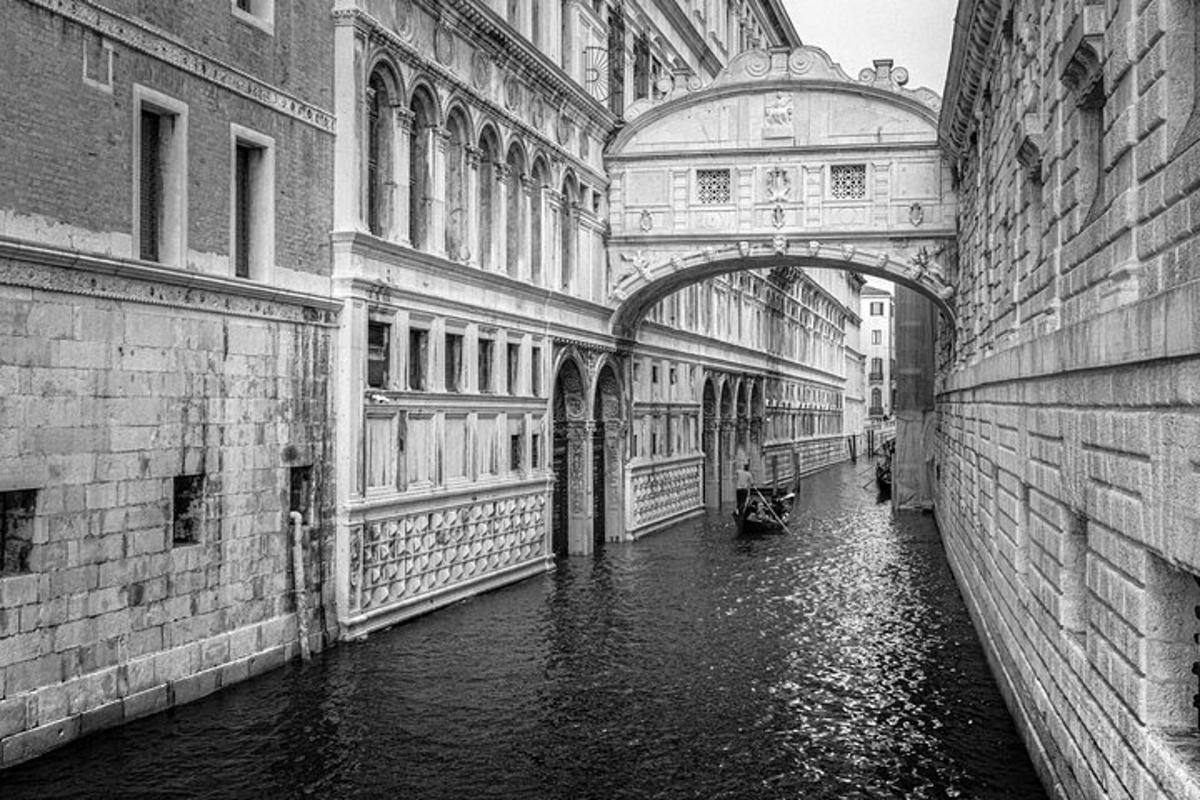 Una fotografía en blanco y negro de un canal entre dos edificios.