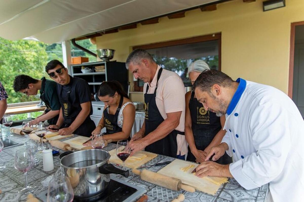 μια ομάδα ανθρώπων που στέκονται γύρω από ένα τραπέζι και ετοιμάζουν φαγητό