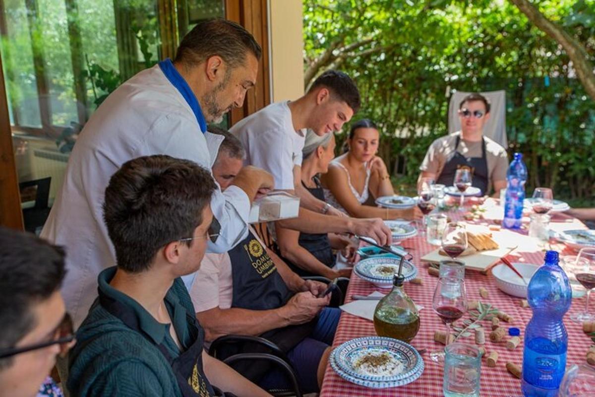 μια ομάδα ανθρώπων που κάθονται γύρω από ένα τραπέζι και τρώνε