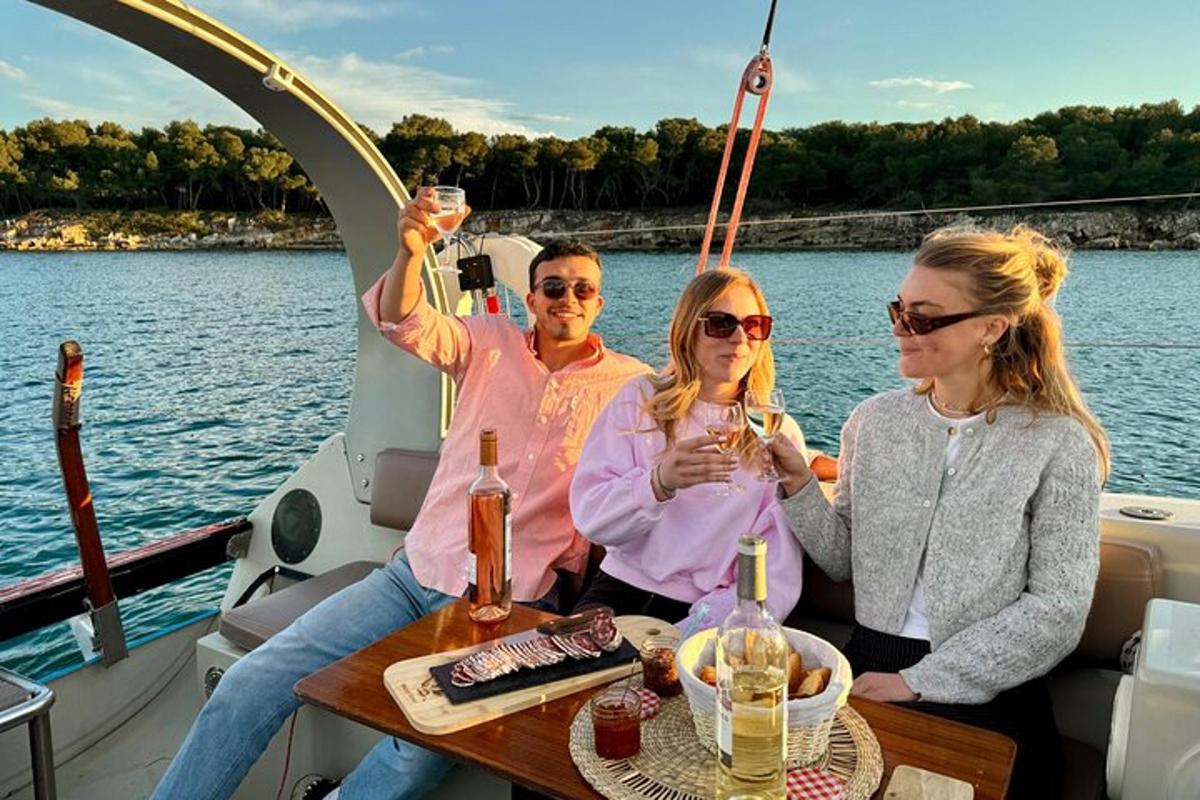 três pessoas sentadas em um barco com taças de vinho
