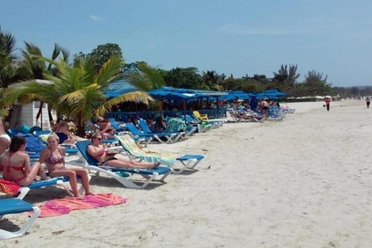 um grupo de pessoas sentadas em cadeiras de jardim na praia