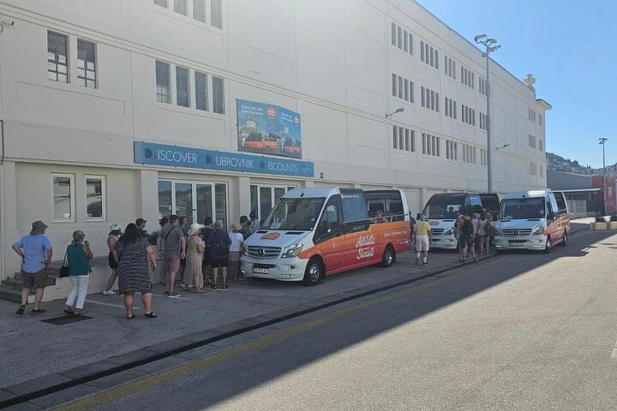 un gruppo di persone in piedi fuori da un edificio