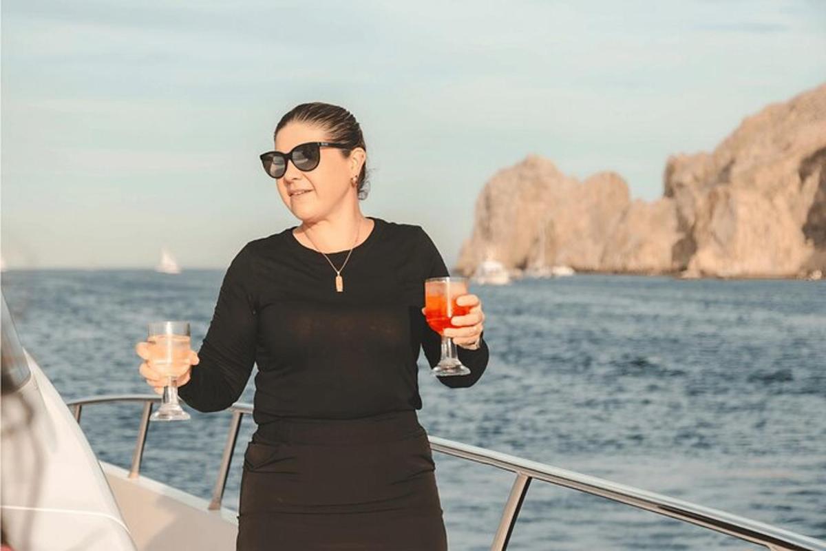 ženska, ki na čolnu drži dva kozarca za vino