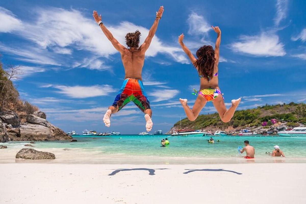 zwei Menschen springen in die Luft an einem Strand