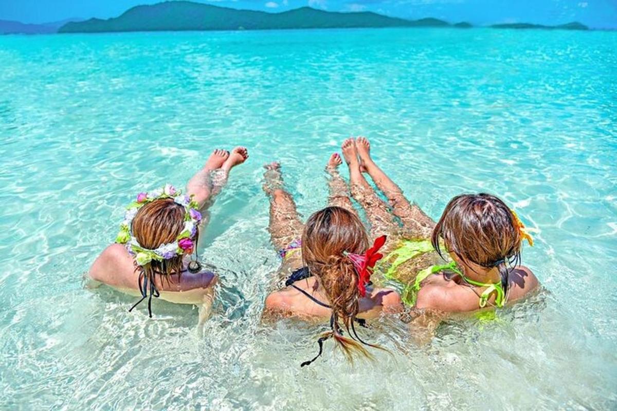três meninas deitadas na água do oceano