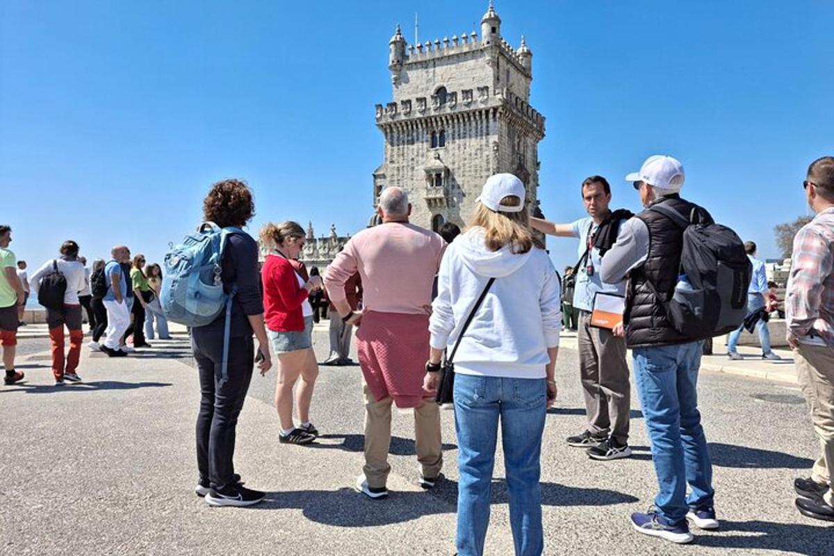um grupo de pessoas em pé em frente à torre inclinada