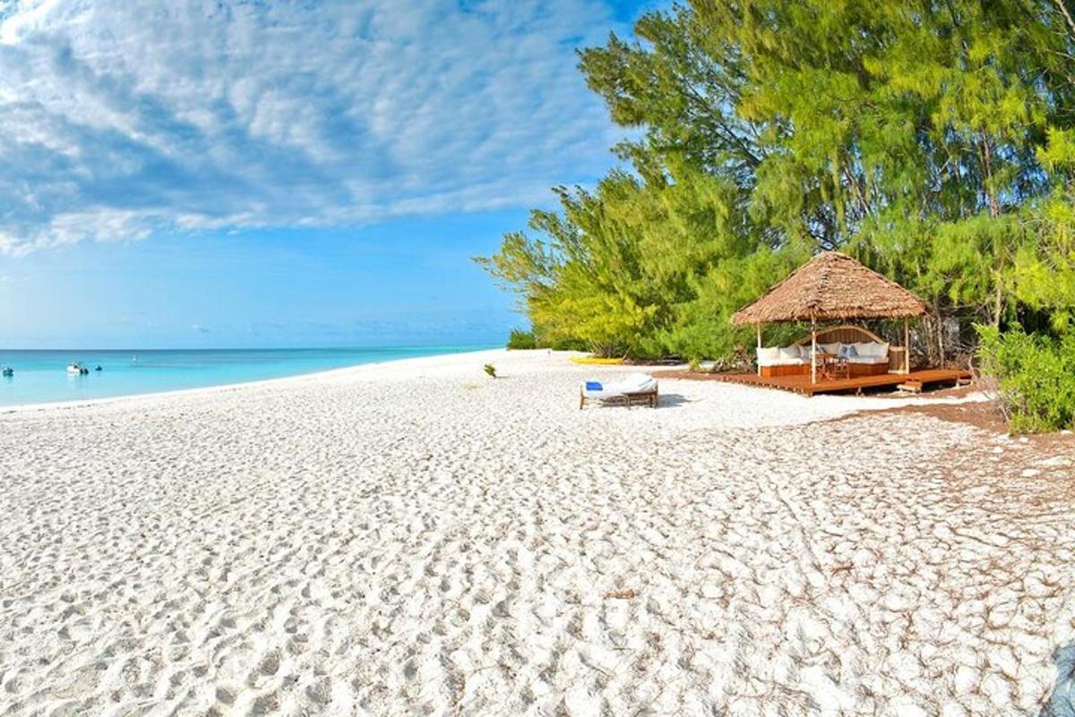 pantai berpasir dengan gazebo dan laut