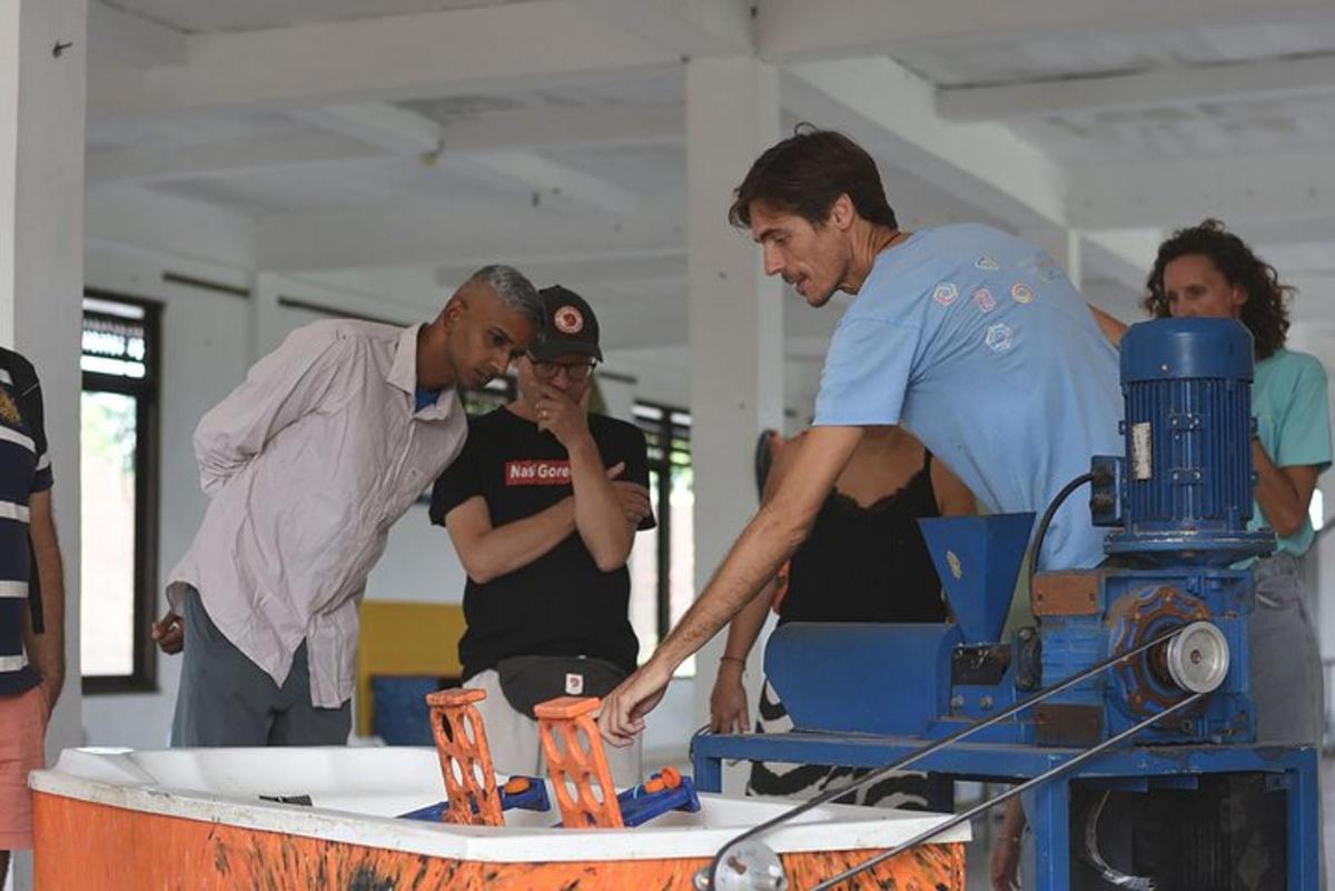 sekumpulan lelaki berdiri di sekeliling meja dengan mesin