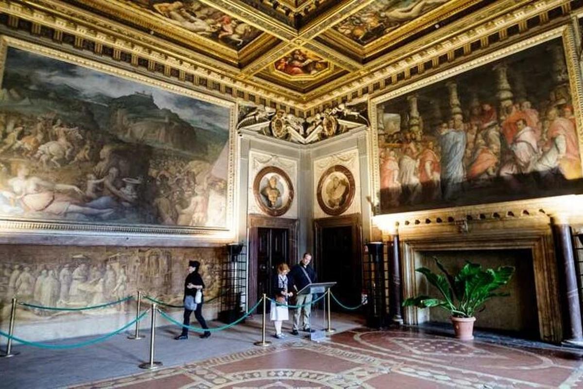people standing in a room with paintings on the walls