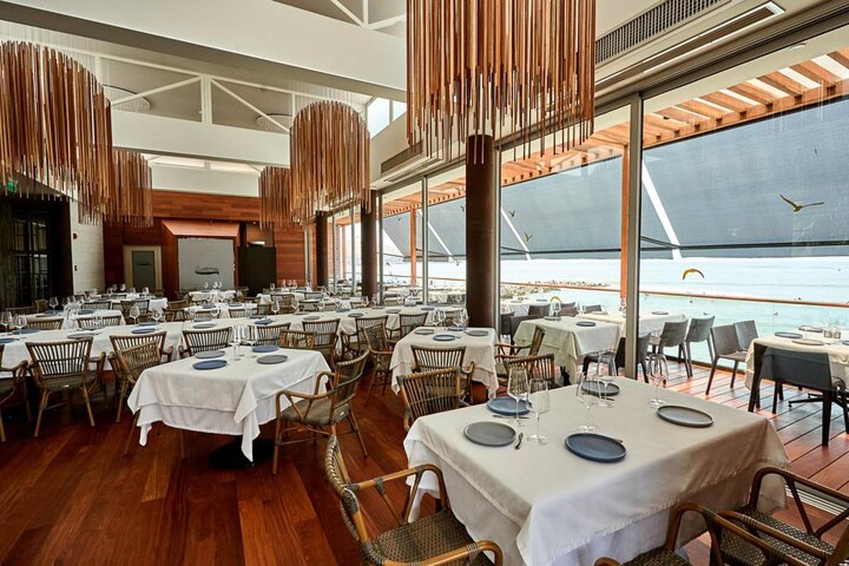 un ristorante con tavoli e sedie bianchi e una grande finestra