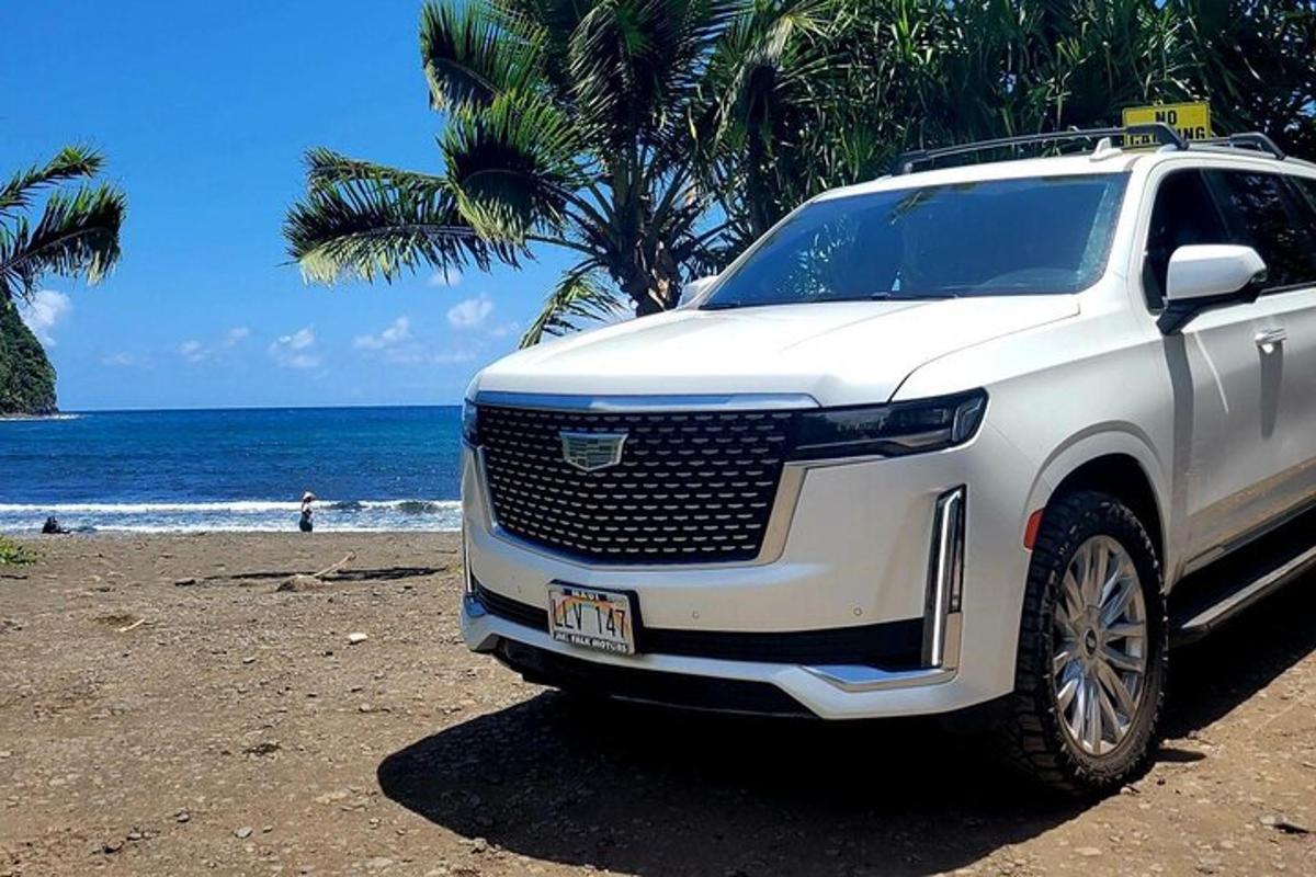 a white truck parked on a beach near the ocean