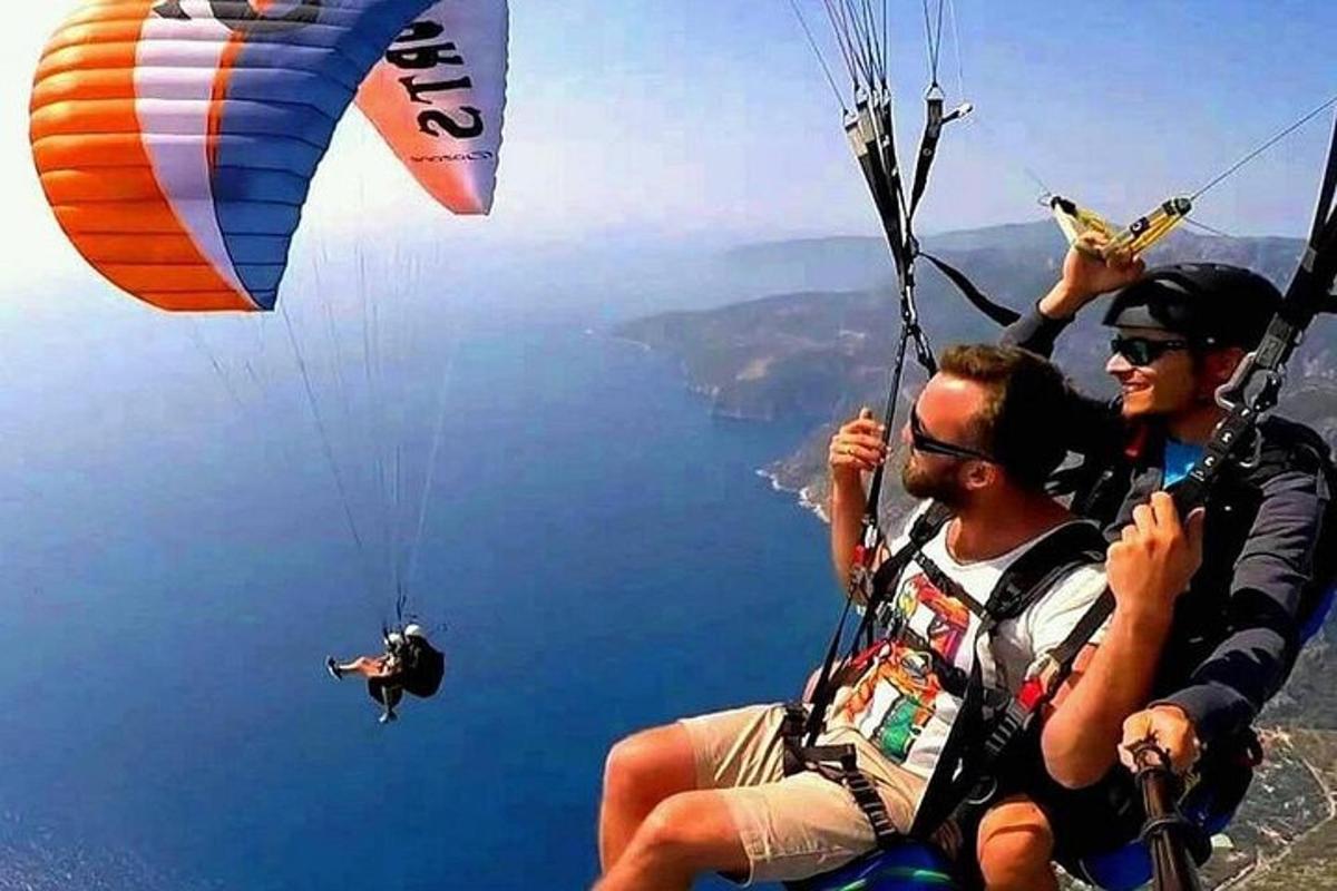 μια ομάδα ανθρώπων που πετάνε χαρταετούς πάνω από το νερό