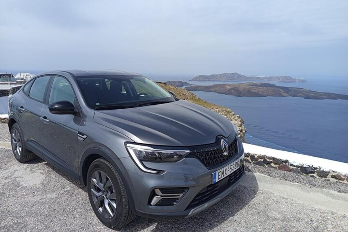 un'auto argentata parcheggiata su una strada vicino all'oceano