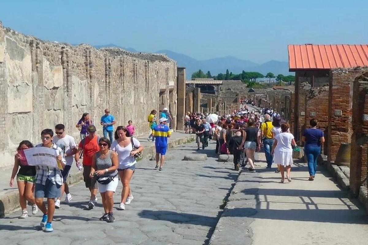 dav lidí procházejících se kolem ruin