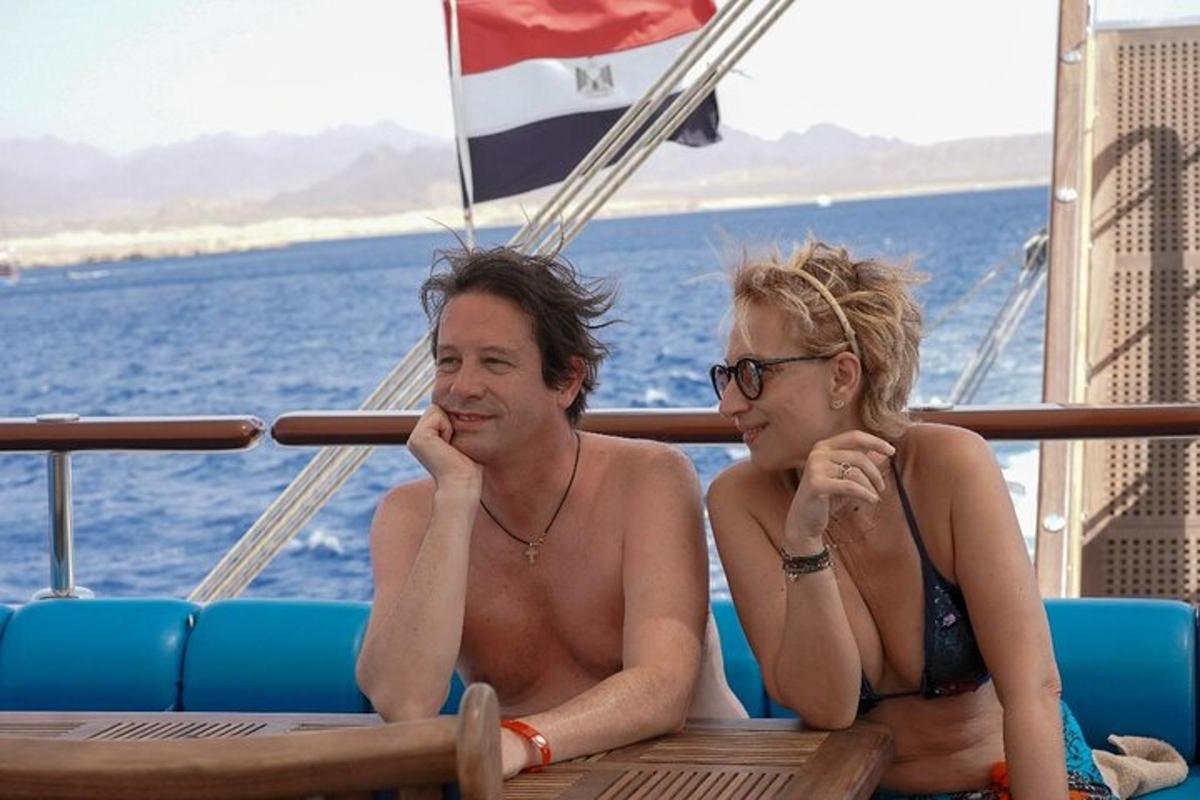 twee mensen zitten op een boot in het water