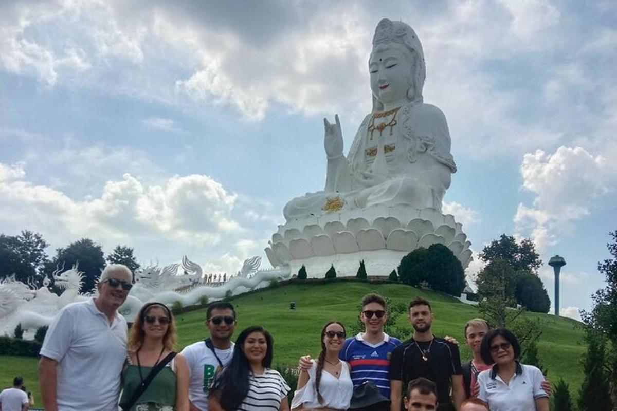 un gruppo di persone in piedi davanti a una grande statua