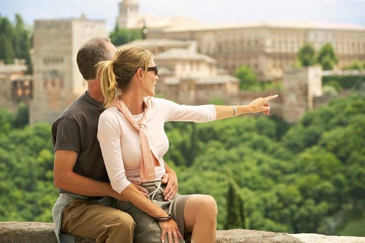 a man and woman sitting on a rock pointing at a city