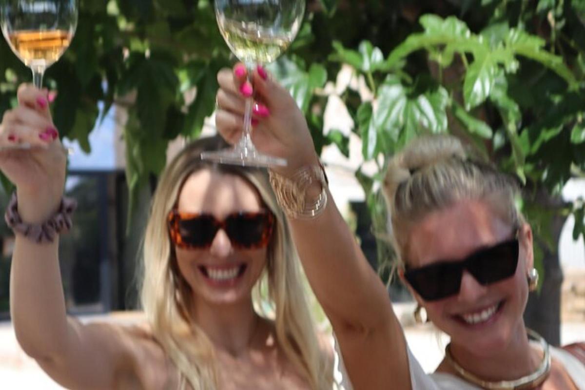 two women are holding up glasses of wine