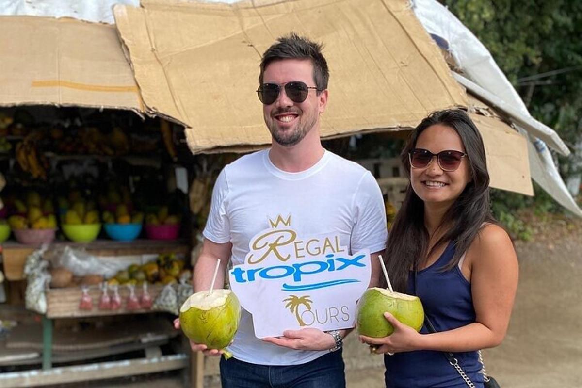 seorang lelaki dan wanita memegang kelapa di hadapan gerai buah-buahan