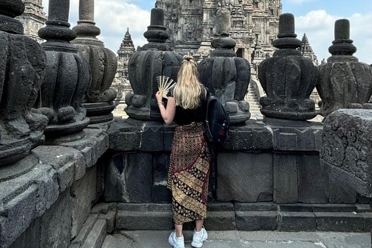 seorang wanita berdiri di dinding sambil memegang kipas angin