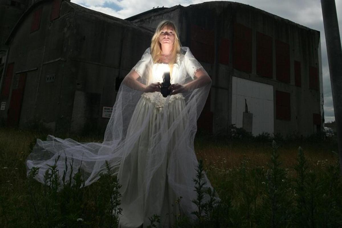 a woman in a dress holding a light in a field