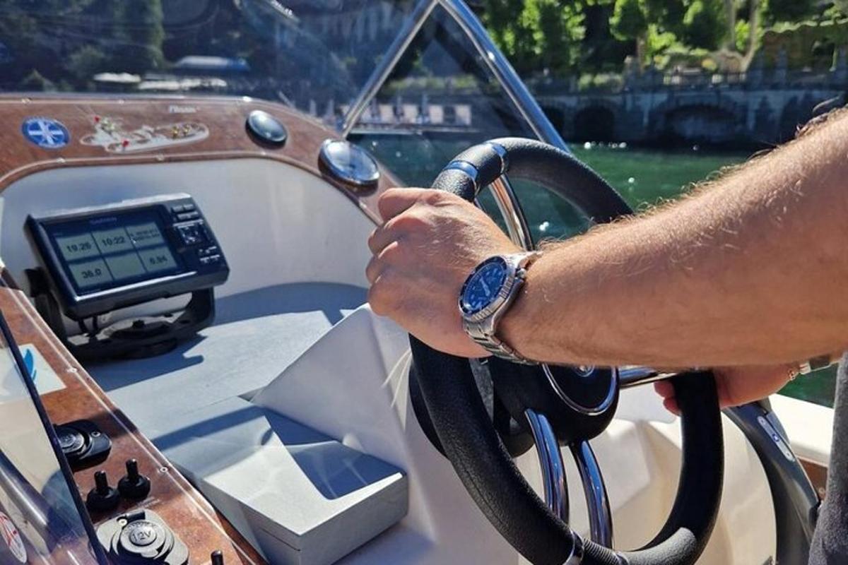 un uomo che tiene il volante su una barca