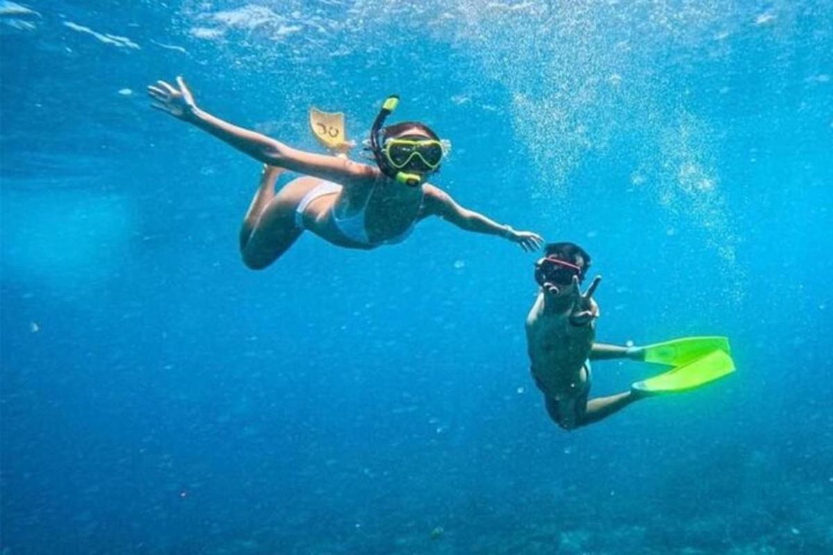 due persone stanno nuotando nell'acqua blu