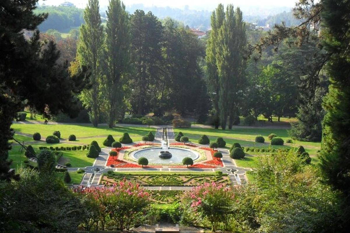 a garden with a fountain in the middle of a park