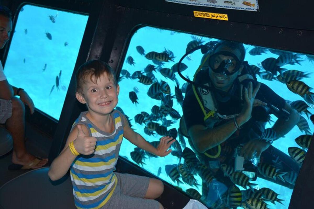 seorang anak laki-laki duduk di depan akuarium ikan